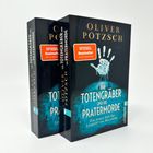 "Der Totengräber und die Pratermorde" von Oliver Pötzsch; Buch mit blauem Handabdruck und rotem "SPIEGEL Bestseller"-Sticker.