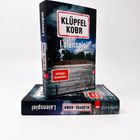 Ein Buchcover mit den Texten "KLÜPFEL KOBR", "Laien­spiel", und "Spiegel Bestseller". Im Hintergrund eine Bank vor Bäumen.