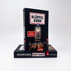 Titel: "Schutzpatron" von KLÜPFEL KOBR. "SPIEGEL Bestseller". Zwei Bücher, eins stehend, eins liegend.