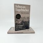 "Teheran Tagebücher" von Raha Nik-Andish. "Nachrichten aus einem belagerten Land." Bücher aufeinander gestapelt.