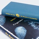 Zwei Bücher, eines mit blauem Einband "Geertjan de Vugt: Der Wunsch zu verschwinden", das andere schwarz mit Fingerabdrücken.