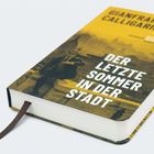 Ein Buch mit dem Titel "Der letzte Sommer in der Stadt", gelber und schwarzer Einband mit Foto, Lesezeichen ragt heraus.