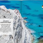 „Sizilien in karibischen Farben“. Weißer Felsen voller Menschen, türkisfarbenes Meer, Segelboot in der Ferne.