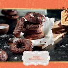 "Salzige Schoko-Donuts" steht unten auf einem Etikett. In der Mitte sind gestapelte Schokoladen-Donuts auf Backpapier.