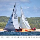 Zwei Segelboote auf einem See, umgeben von grüner Landschaft. Nummern auf den Segeln: SS 22 SWE 885 288 und SS 22 SWE 354. Unten ein Kalender für März.
