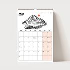 MAI, Chiemgauer Alpen 2027. Illustration eines Berges mit roter Sonne. Kalenderdaten mit markierten Feiertagen und Ereignissen.