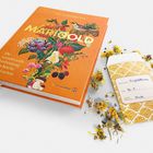 Ein orangefarbenes Buch mit dem Titel "MARIGOLD" und der Unterzeile "Die wundervolle Verbindung von Küche und Garten". Daneben ein Samenpäckchen mit gelben Blüten.