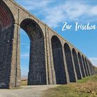 Text: "Zur Irischen See". Großes Steinviadukt mit mehreren Bögen, blauer Himmel im Hintergrund.
