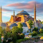 Ich kann keine Texte oder Logos erkennen. Eine große historische Moschee mit vier Minaretten, bewachsen von Bäumen umgeben.