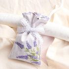 Kleines Stoffbeutelchen mit Lavendelmotiv, verziert mit einer Spitzen-Schleife, hängt an einem Kleiderbügel.