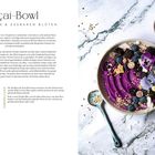 Açaí-Bowl mit Beeren und essbaren Blüten. Ein purpurnes Dessert mit Beeren, Blüten und knusprigen Elementen.