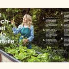 Ein Hochbeet bietet viele Vorteile. Eine lächelnde Frau in einer Schürze erntet Gemüse in ihrem üppigen Hochbeet.