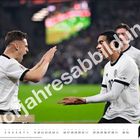 "Vorjahresabbildung" ist groß über zwei jubelnde Fußballspieler in weißen Trikots mit schwarzen Details geschrieben.