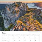 Kalenderblatt für März. Das Bild zeigt einen felsigen Berggipfel mit Kreuz im Sonnenaufgang, darüber blauer Himmel.