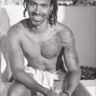 03. Kalender mit einer Liste von Tagen. Ein lächelnder Mann mit Tattoos und Dreadlocks sitzt draußen mit einem Handtuch.