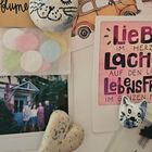 Karte mit Text: "Liebe im Herzen, Lachen auf den Lippen, Lebensfreude im ganzen Körper". Katze, Auto, Herzdeko, Konfettis.