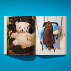 Links ein weißer Teddybär, rechts ein blauer Plüsch-Esel, beide skurril in Szene gesetzt.