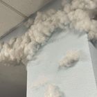 Eine Wand in Blau mit angeklebten Wolken aus Watte, die bis zur Decke reichen.