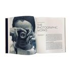 Rechts: "Pauline Behrmann, The Photographic Works". Links: Schwarz-Weiß-Foto einer Person mit Kamera, die durch eine Brille schaut.