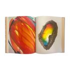 Keine Texte sichtbar. Links abstrakte Kunst in Rot-Orange, rechts ein Geode mit regenbogenfarbenem Inneren.