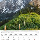 März 2027. Kalender mit Berglandschaft: grüner Hang, dahinter schroffe, schneebedeckte Berge unter blauem Himmel.