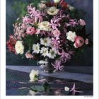 Kalenderseite März 2027, mit einem Blumengesteck aus rosa, weißen und roten Blüten, darunter Nelken und Rosen.