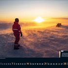 Zitat: "SONNE ÜBER DER ANTARKTIS" – Person in rotem Anzug steht im Schneesturm, dahinter zwei Schneemobile. Unten Kalender März 2021.