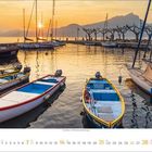 5 2022, 1 2 3 4 5, Boote am Ufer, beleuchtete Gebäude, Abendstimmung, ruhiges Wasser, Palmen im Hintergrund.