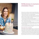 "Willkommen in meinem Zimtliebe-Chaos" steht rechts. Links lächelt eine Frau neben einem bunten Kuchen und Cupcakes.
