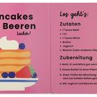 "Pancakes mit Beeren. Zutaten: Mehl, Ei, Milch, Butter, Joghurt, Beeren. Anleitung: Mischen, braten, servieren." Links Illustration von Pancakes mit Beeren.