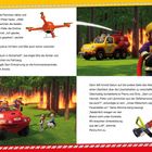 Ein Feuerwehrmann steht mit einem Schlauch neben einem Feuerwehrauto im brennenden Wald. Eine Drohne fliegt.