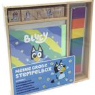 "Meine große Stempelbox. Enthält: 1 Rätselblock, 4 Ausmalkarten, 5 Holzstempel, 7 Stempelkissen, 12 Bogen Buntpapier." Illustration einer fröhlichen blauen Cartoon-Figur.