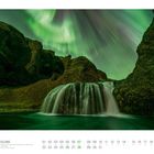 03 ISLAND, Nordlichter über dem Wasserfall Stjórnarfoss, Südisland. Ein Wasserfall in grüner Landschaft, Nordlichter am Himmel.