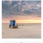 03, Badekarren am Strand auf der Insel Borkum, Niedersachsen, Deutschland. Blauer Himmel, rosa Sonnenaufgang und Sand.