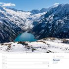 01. Woche. Januar 2027. Schneebedeckte Berge und ein türkisfarbener See unter blauem Himmel.