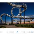 Kalender mit Monatsansicht März und beleuchteter Achterbahn-Skulptur vor Abendhimmel, Namen und Wochentage darunter.