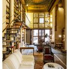 02 JANUAR. Raum mit hohen Bücherregalen, antiken Möbeln und einer kunstvoll verzierten Decke.