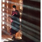 02 JANUAR. Ein Junge in einem roten Gewand steht in Sonnenstrahlen, die durch eine Wandöffnung fallen.