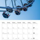 Kalender für März 2027. Oberhalb große, moderne Riesenrad-Illustration vor blauem Himmel.