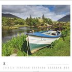 „Bundorragha River, Connemara Loop, County Mayo“. Ein altes Boot liegt am Ufer eines Flusses, umgeben von grüner Natur.