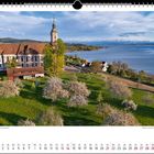 "Blick zur Basilika Birnau – im Hintergrund die Alpenkette." Landschaft mit Kirche, blühenden Bäumen und See.
