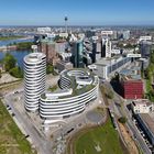 Beschriftete Gebäude: ALTO, Win Win, Colorium, SIGN!, DOCK, LARGO, The Float, Capricorn-Haus. Urbaner Raum mit Fluss.