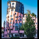 III 2027. Kalender mit Bild eines farbenfrohen Gebäudes, Bäume im Vordergrund, blauer Himmel im Hintergrund.