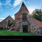 Preston Mill, Kalender 2027 Februar. Rustikales Steingebäude mit roten Ziegeldächern, Sonnenstrahlen im Hintergrund.