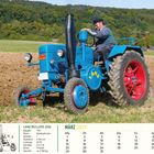 "Lanz Bulldog 2206, Baujahr 1951, Glühkopfmotor. Blau-roter Traktor auf einem Feld, Fahrer mit Mütze."