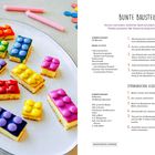 "Bunte Bausteine" Rezept: Zitronenkuchen mit Smarties. Bunte Kuchenstücke wie Bausteine platziert auf einem Teller.