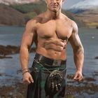 März-Kalenderblatt. Ein muskulöser Mann trägt einen Kilt. Hinter ihm eine malerische Landschaft mit Bergen.