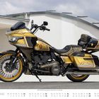Auf dem Bild steht "182", "Harley-Davidson", "CVO", "MÄRZ". Ein gold-schwarzes Motorrad neben einer weißen Wand.