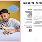 "BLAUBEER-CHEESECAKE: Ohne Boden, aber umso mehr Geschmack." Ein Mann mit Basecap isst lachend einen Kuchen.