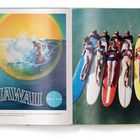 Links steht "HAWAII" mit einem Pan-Am-Logo daneben. Rechts liegen sechs Menschen auf bunten Surfbrettern im Wasser.